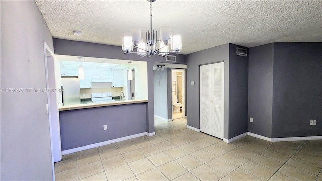 interior space with an inviting chandelier, a textured ceiling, light tile patterned flooring, and sink