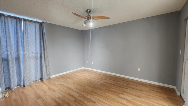 empty room featuring light hardwood / wood-style floors, ceiling fan, and a textured ceiling