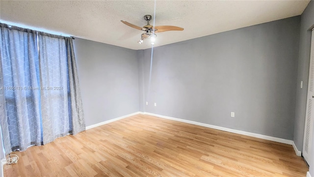 empty room with light wood-type flooring, a textured ceiling, and ceiling fan