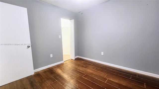 empty room featuring dark wood-type flooring