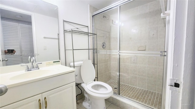 bathroom featuring tile patterned floors, a shower with door, vanity, and toilet