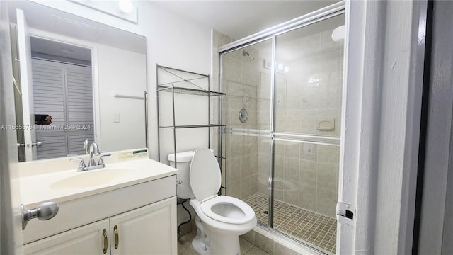 bathroom featuring vanity, tile patterned flooring, toilet, and an enclosed shower