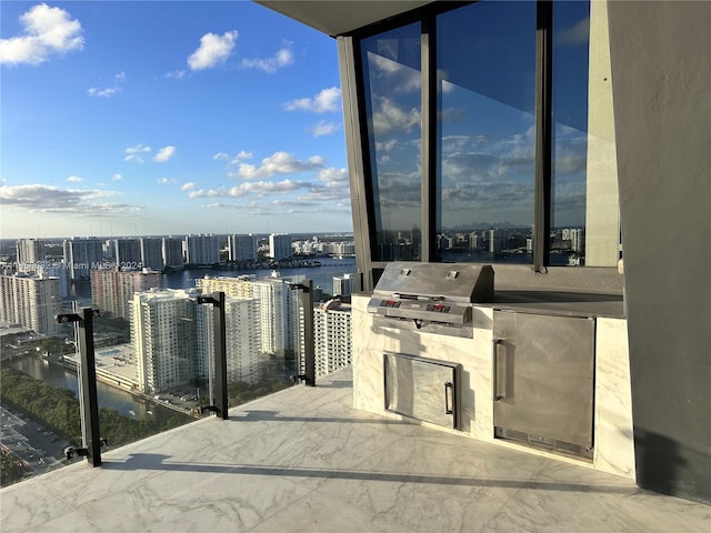 exterior space with a grill, a water view, and exterior kitchen