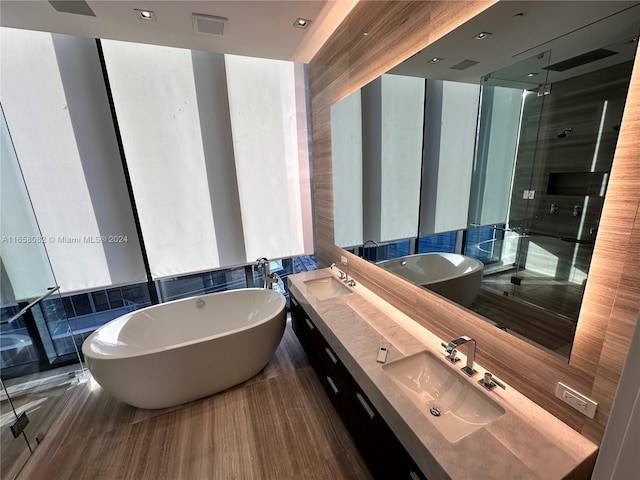 bathroom with hardwood / wood-style floors, vanity, and independent shower and bath