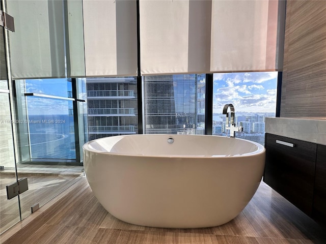 bathroom featuring wood-type flooring and a tub to relax in