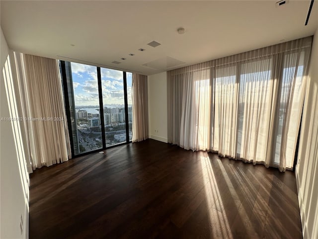 empty room featuring dark hardwood / wood-style floors and floor to ceiling windows