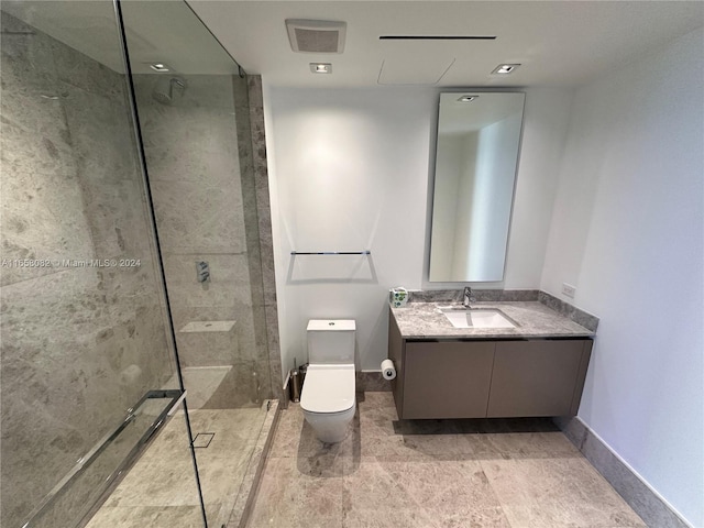 bathroom featuring tiled shower, vanity, and toilet