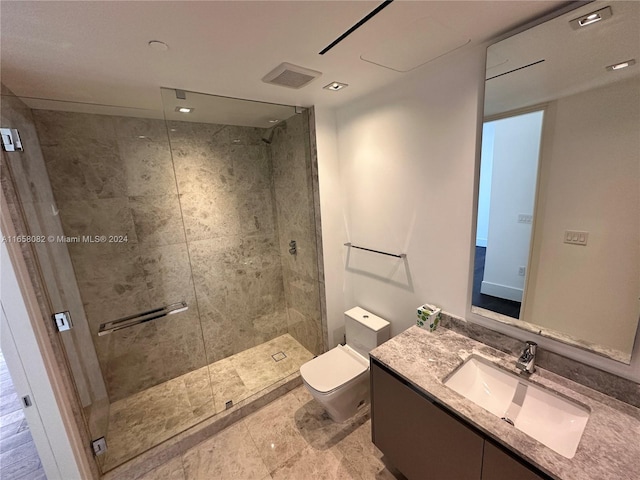 bathroom featuring vanity, toilet, and a shower with shower door