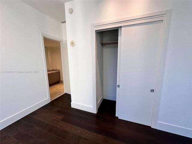 unfurnished bedroom featuring dark hardwood / wood-style floors and a closet