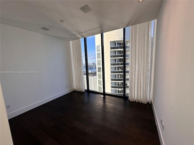 unfurnished room featuring dark hardwood / wood-style flooring and expansive windows