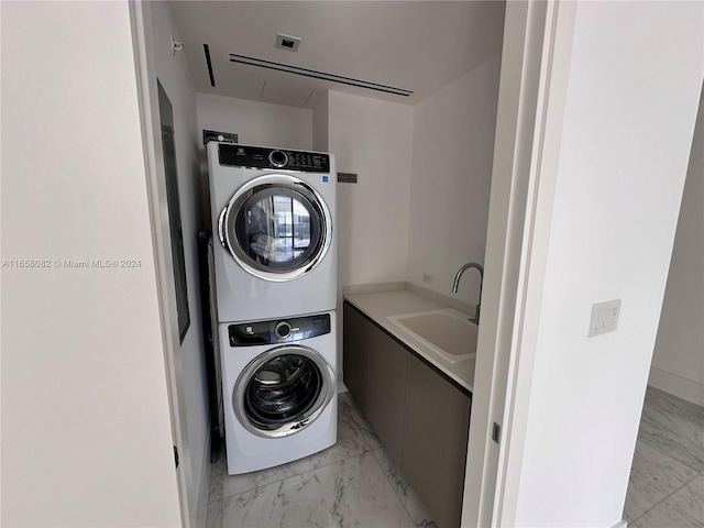 clothes washing area featuring sink and stacked washer and clothes dryer