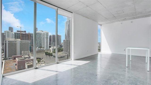 spare room featuring floor to ceiling windows and concrete flooring