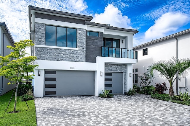 8095 Crystal Downs Ave, Boca Raton, FL 33434 - contemporary home featuring a balcony, stone siding, decorative driveway, an attached garage, and stucco siding