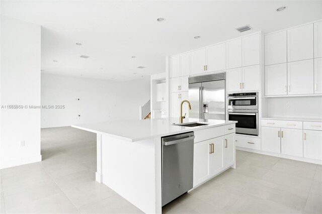 8095 Crystal Downs Ave, Boca Raton, FL 33434 - kitchen with stainless steel appliances, white cabinetry, light countertops, an island with sink, and recessed lighting