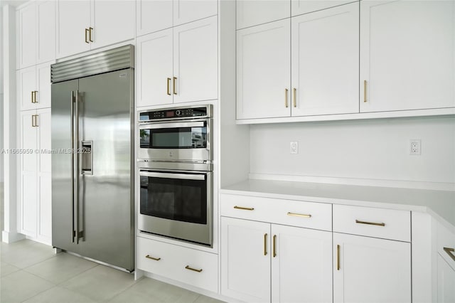 8095 Crystal Downs Ave, Boca Raton, FL 33434 - kitchen with stainless steel appliances, light countertops, white cabinets, and light tile patterned floors