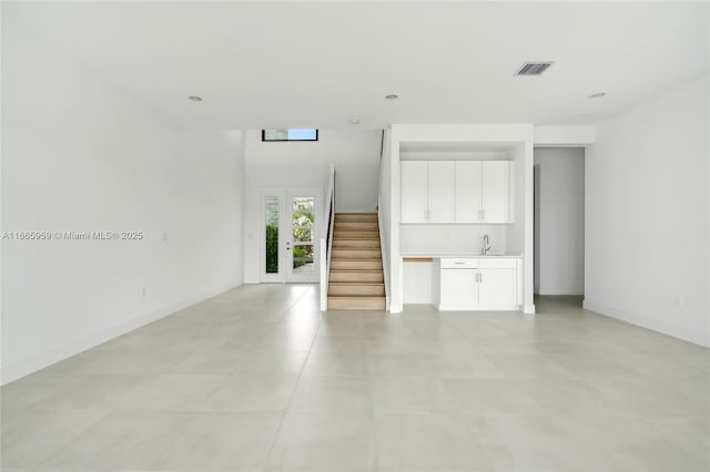 8095 Crystal Downs Ave, Boca Raton, FL 33434 - unfurnished living room with bar with sink, stairs, and light tile patterned floors