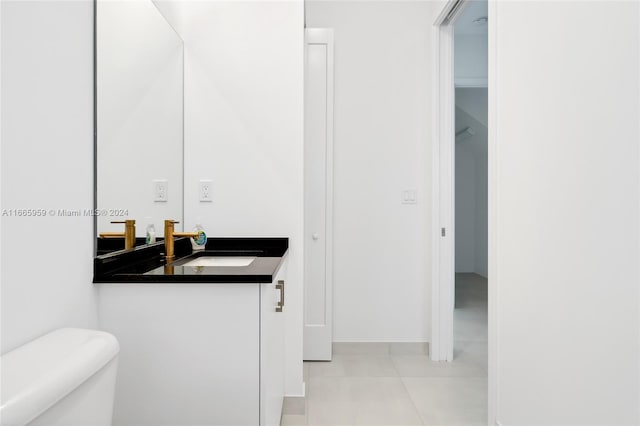 bathroom featuring tile patterned flooring, vanity, and toilet