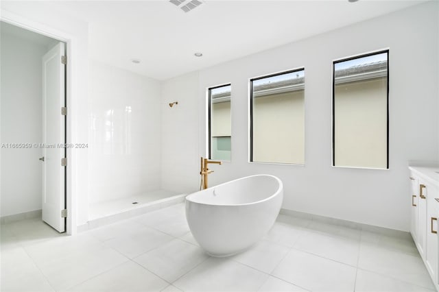 bathroom with tile patterned flooring, vanity, and separate shower and tub