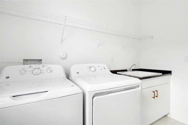 washroom featuring sink, washing machine and clothes dryer, and cabinets