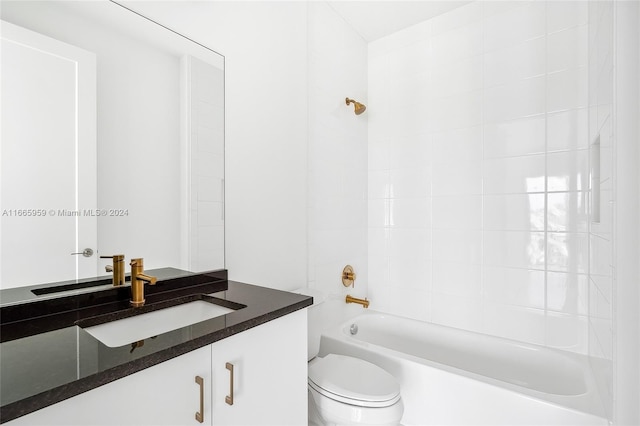 full bathroom featuring tiled shower / bath, vanity, and toilet