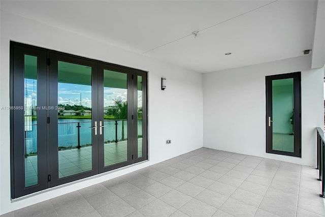 spare room featuring light tile patterned floors and french doors