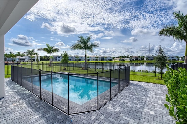 view of swimming pool with a patio, a water view, and a yard