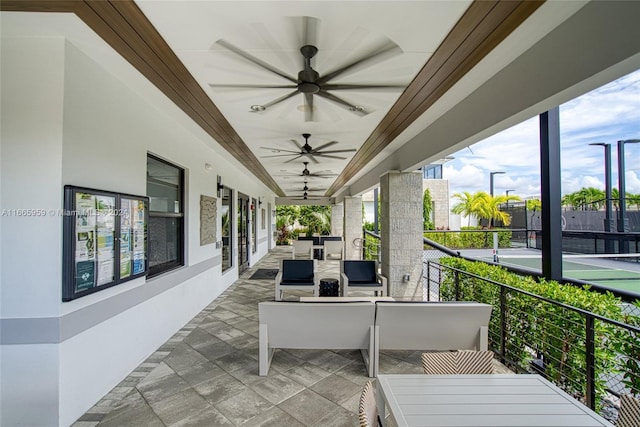 view of patio with ceiling fan and a balcony