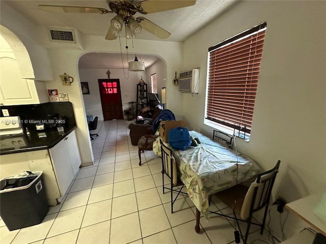 kitchen featuring white cabinets, ceiling fan, light tile patterned floors, and a wall mounted AC