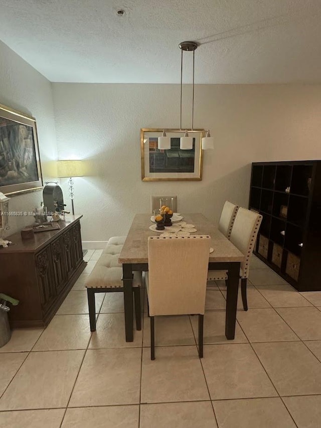 dining space featuring a textured ceiling and light tile patterned floors