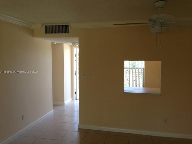 unfurnished room with ornamental molding, ceiling fan, and light tile patterned flooring