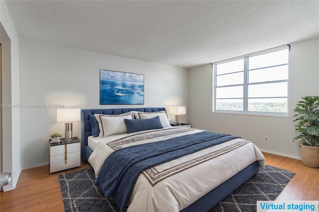 bedroom with wood-type flooring and a textured ceiling