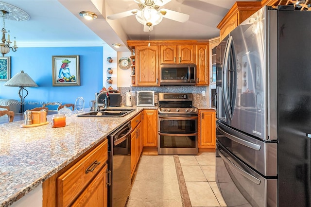 kitchen with tasteful backsplash, sink, ornamental molding, light tile patterned flooring, and appliances with stainless steel finishes