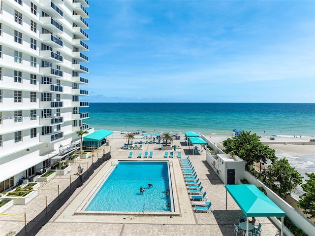 view of swimming pool featuring a beach view and a water view