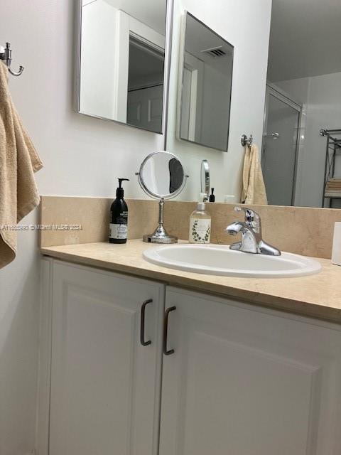 bathroom with vanity and a shower with shower door