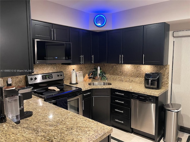 kitchen with tasteful backsplash, sink, stainless steel appliances, and light stone counters