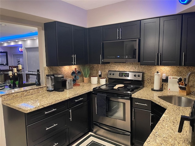 kitchen with backsplash, sink, stainless steel appliances, and light stone counters