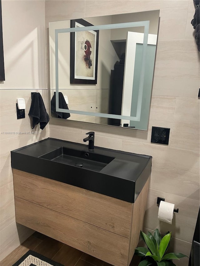 bathroom with tile walls, vanity, and hardwood / wood-style floors