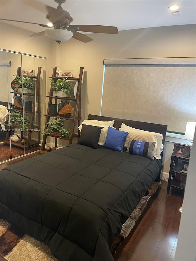 bedroom with a closet, ceiling fan, and dark hardwood / wood-style floors