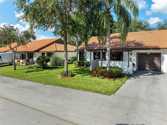 view of front of home with a garage and a front lawn