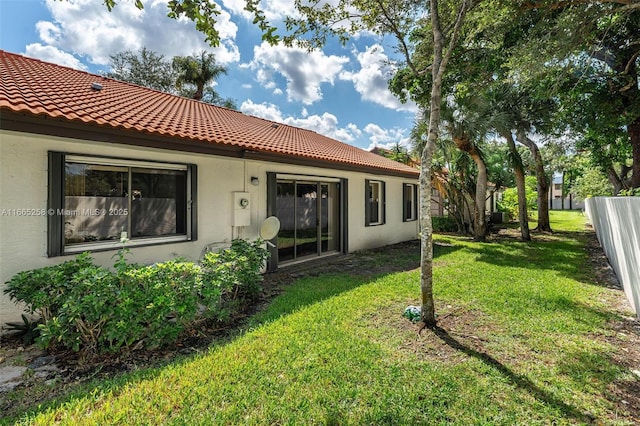7037 Marlberry Ln, Tamarac, FL 33321 - rear view of house with stucco siding, a tile roof, fence, and a lawn