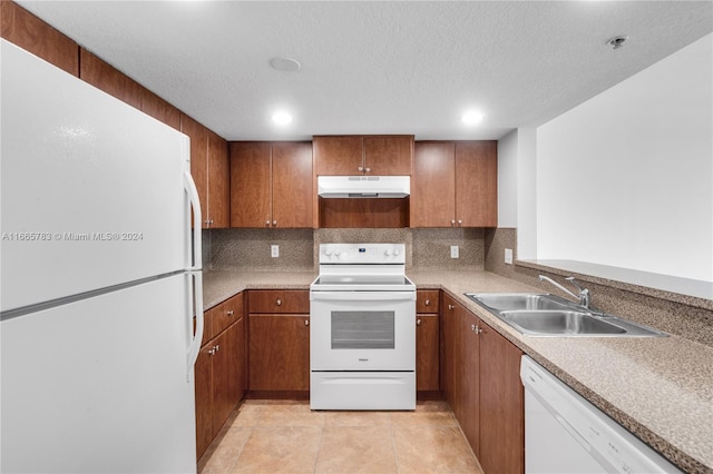 kitchen featuring backsplash, sink, a textured ceiling, and white appliances