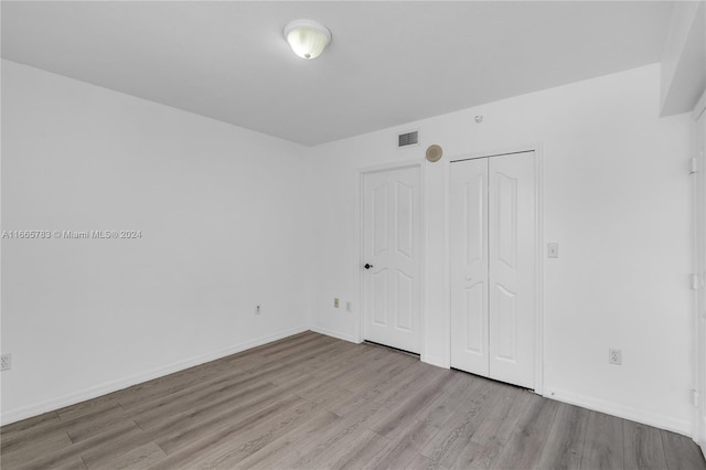 unfurnished bedroom featuring a closet and light wood-type flooring