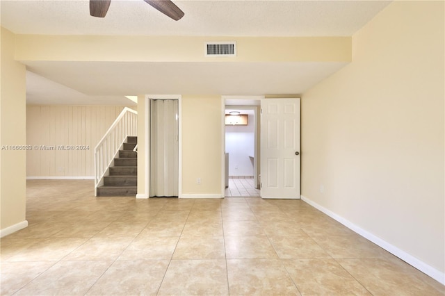 unfurnished room with a textured ceiling, light tile patterned flooring, and ceiling fan