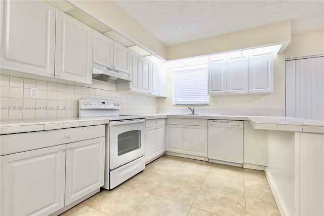 kitchen with range with electric stovetop, tasteful backsplash, white cabinets, dishwasher, and tile counters