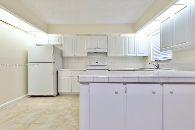 kitchen featuring white cabinets, sink, white appliances, tile countertops, and decorative backsplash