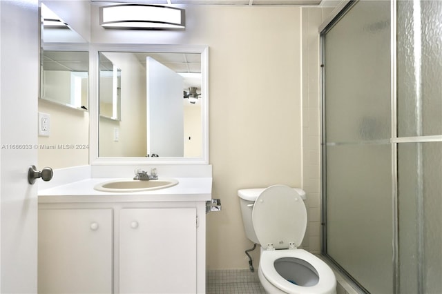 bathroom with walk in shower, vanity, toilet, and tile patterned floors