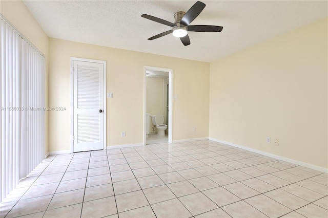 unfurnished room with ceiling fan, a textured ceiling, and light tile patterned flooring