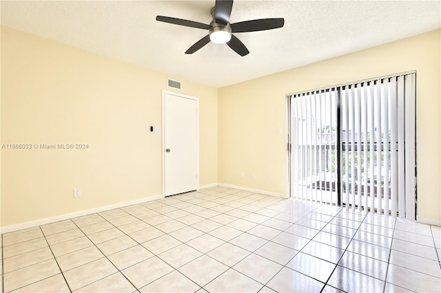 tiled empty room featuring ceiling fan and a textured ceiling