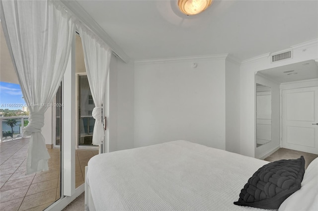 bedroom with crown molding and light tile patterned floors