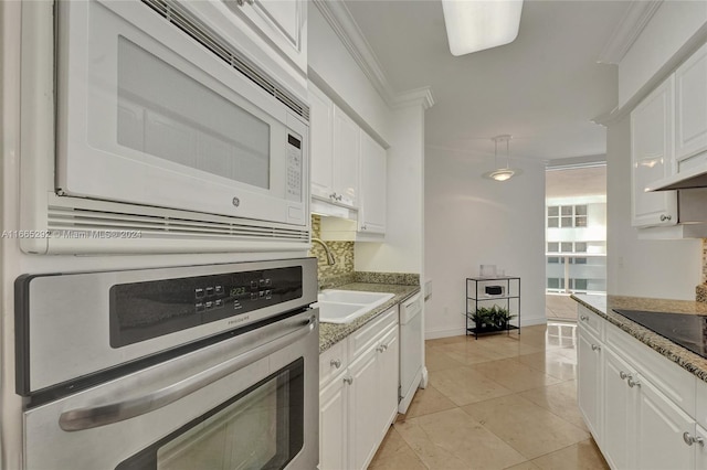 kitchen with ornamental molding, white appliances, and white cabinetry